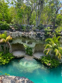 an outdoor swimming pool surrounded by trees and rocks with steps leading up to the water