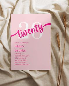 a pink birthday party card with the number twenty on it and some dried flowers in front