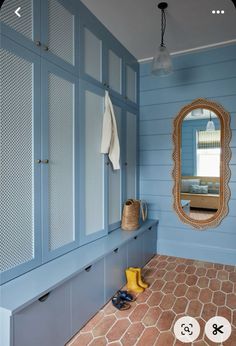 a bathroom with blue walls and tile flooring next to a mirror on the wall