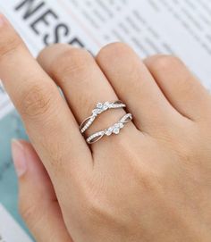 a woman's hand with two rings on top of her finger, and the ring is