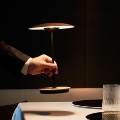 a person is lighting a candle on a table