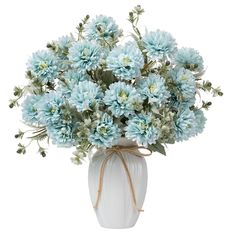 a white vase filled with lots of blue flowers