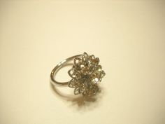 "Vintage 1960s Sarah Coventry Silver tone metal \"SYMPHONY\" rhinestone cocktail ring. Adjustable ring. All rhinestones are present, intact, and prong set. Excellent condition. Signed \"SARAH COVENTRY\"." Vintage Silver Diamond Ring For Vintage Events, Vintage Flower Ring For Wedding With Prong Setting, Vintage Silver Rings For Party, Vintage Silver Cluster Ring For Wedding, Vintage Flower Ring With Prong Setting For Wedding, Vintage Rhinestone Rings As A Gift, Vintage Rhinestone Rings For Gift, Vintage Rhinestone Rings For Gifts, 1960s Vintage Southern Jewelry