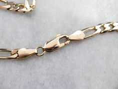 "So often labeled a 'guy's chain', this link style is the perfect answer for a lady looking for a stylish, lightweight pendant chain! Long enough to wear layered with other pieces, this will slip securely under a shirt, as well, making it a nice piece to wear with a talisman or religious medallion. Metal: 14K Yellow Gold Width of Chain: 4.4 mm Length of Chain: 20 1/2 Inches Marks: \"14KT Italy\" Stamped on the clasp SKU #: 99CJJ00X Each piece has been identified and graded by a Graduate Gemologi Jewelry Basics, Gold Chain Pendant, Gold Figaro Chain, Chain Layering, Figaro Chain Necklace, Basic Jewelry, Cameo Ring, Layered Chains, Figaro Chains