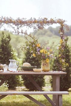 a picnic table with flowers and vases on it