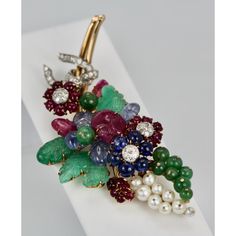 This is part of Chairish’s Fine Jewelry assortment.  Gem set Diamond Brooch w/Certificate 18K  This gorgeous gem set Diamond brooch is a bit Tutti Frutti plus. This brooch is large 8.5 cm long or 3 1/4" at the widest it is 3 cm and it weights 34.4 grams. The brooch consists of (4) Green Emerald carved leaves, (8) round beads, (4) Ceylon Sapphire carved leaves, (3) carved Ruby leaves, 20 small Ruby beads, (6) deep Blue Sapphires, (9) pearls cultured and numerous Diamonds all on 18K yellow gold. This comes with a certificate stating the Jade is real as are the stones. This is very special and a piece you will hold on to for life. Just exquisite. Do not wait or you will be too late this is a very special piece I purchased through Sothebys Auction House.  Please reference the measurements note Formal Yellow Gold Multi-stone Brooches, Luxury Multi-stone Brooches For Anniversary, Elegant Multi-stone Collectible Brooches, Formal Fine Jewelry Brooches With Jewels, Formal Multi-stone Brooches In Fine Jewelry Style, Formal Multi-stone Brooch Fine Jewelry, Elegant Multi-stone Brooches For Formal Occasions, Formal Multi-stone Brooch In Fine Jewelry Style, Luxury Evening Gemstone Brooches