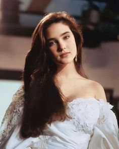 a woman with long hair wearing a white dress