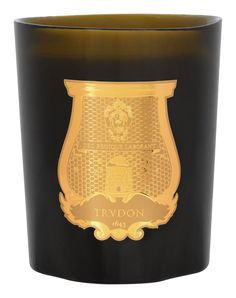 a black and gold candle with a golden emblem on it