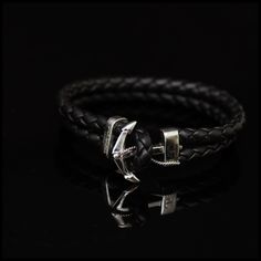 Made using beautiful black Italian Nappa Leather, this masculine bracelet boasts a large Ship's Anchor forged from Sterling Silver. The Anchor acts as the bracelet's sturdy toggle close.  Simply hook the Leather loop over the Anchor's pointed flukes and adjust the Sterling Silver sliding lock to secure. In a maritime context, the Anchor is the most secure object in a sailor's life, making it the perfect representation of stability and strength. SPECIFICATION -This is an adjustable bracelet  FEATURES -Sterling Silver -Italian Nappa Leather Minimalist Formal Bracelet With Leather Strap, Minimalist Leather Strap Bracelet For Formal Occasions, Minimalist Leather Strap Bracelets For Formal Wear, Black Leather Strap Wristband As Gift, Luxury Adjustable Leather Bracelet For Everyday Wear, Classic Black Braided Bracelets For Everyday, Black Luxury Leather Bracelet For Everyday, Classic Black Braided Bracelets, Modern Formal Bracelets With Black Band