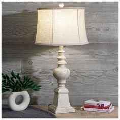 a white lamp sitting on top of a wooden table