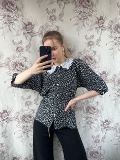 This vintage black and white floral blouse epitomizes the elegant tailoring of the 70s era. With its timeless design and sophisticated floral pattern, it exudes a sense of refined femininity. Perfectly tailored to flatter the silhouette, this women's shirt is a stylish nod to retro fashion with enduring charm. - Good vintage condition - TAG SIZE: No information  - Fabric information: 100% viscose Estimated to fit XS-S-M-L based on your desired fit. Measurements (laying flat): - Shoulders (back): Fitted Printed Blouse For Workwear, Black Collared Blouse With Floral Print, Printed Fitted Blouse For Office, Fitted Printed Blouse For Office, Retro Black Workwear Shirt, Retro Black Shirt For Work, Office Floral Print Short Sleeve Blouse, Vintage Collared Top For Office, Floral Print Short Sleeve Blouse For Office