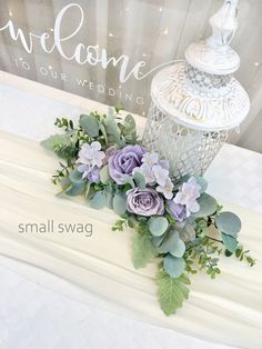 a bouquet of flowers sitting on top of a table next to a white light fixture