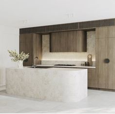 a modern kitchen with marble counter tops and wooden cabinetry, along with an island in the middle