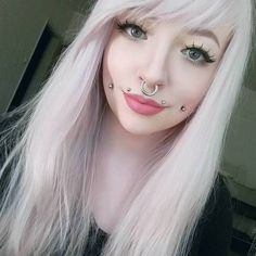 a woman with white hair and piercings on her nose