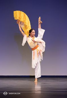 a woman is dancing on stage with an umbrella