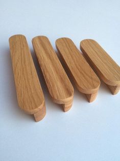 three wooden handles are lined up on a white surface