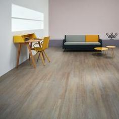 a living room filled with furniture and a table next to a couch on top of a hard wood floor