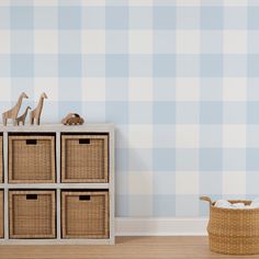 toy giraffes on top of four baskets in front of a blue and white checkered wall