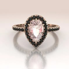 Stunning pear shape Morganite engagement ring. This ring is made in solid 14K Rose Gold. The center stone is surrounded by a delicate halo set with genuine Black Diamonds as well as the shank (0.25ct). Engagement Ring With Black Accents, Pink And Black Engagement Ring, Black Pear Engagement Ring, Black Diamond Pear Engagement Ring, Color Engagement Rings Vintage, Black Diamond Rose Gold Engagement Ring, Black Diamond Engagement Ring Halo, 14k Rose Gold Jewelry, Black Diamond Wedding Rings