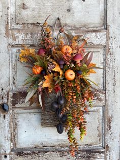 a bouquet of flowers is hanging on the front door to display it's autumn foliage