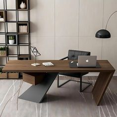 an office desk with a laptop on it in front of a bookshelf and shelves