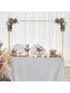 a table topped with plates and flowers on top of a white cloth covered tablecloth