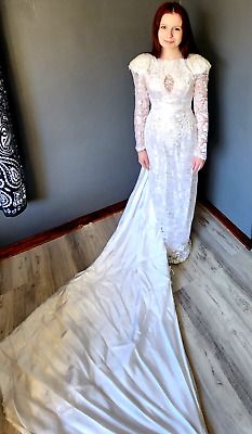 a woman in a white wedding dress standing on the floor