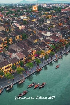 an aerial view of boats in the water and buildings on both sides of the river