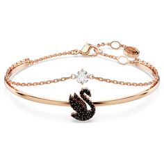 Adorn your wrist with the beauty of Swarovski’s signature emblem. This rose gold-tone plated jewelry features a rigid band with an elegant swan motif, expertly decorated with a pavé of jet black Swarovski ReCreated™ crystals. A secondary chain is also attached with a clear Swarovski Zirconia at the center. Intense yet radiant, this bangle is a perfect way to inject your style with intrigue. Swarovski Swan, Swarovski Bracelet, Jewelry Accessories Ideas, Elegant Bracelet, Swarovski Jewelry, Girly Jewelry, Metal Bracelets, Black Rose, Jewelry Plate