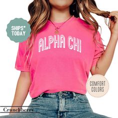 a woman wearing a pink shirt with the words, alpha chi in white on it