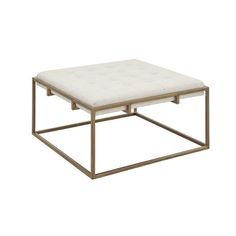 a square coffee table with a metal frame and white upholstered cushion on top