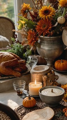 a thanksgiving table setting with pumpkins, sunflowers and other autumn decor items