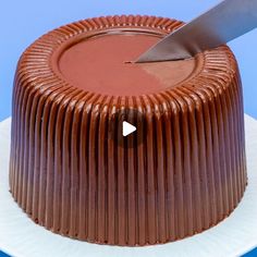 a chocolate cake with a knife sticking out of the top and on a white plate