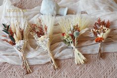 four dried flowers are sitting on a bed