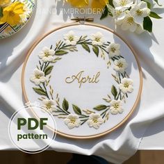 a white table topped with flowers and embroidery