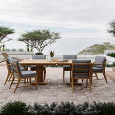 a wooden table with chairs around it on a patio