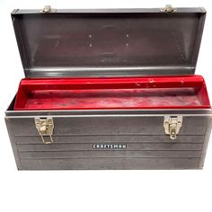 an old metal tool box with red interior