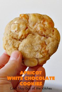 a hand holding up a cookie with white chocolate chips on it and the words apricot white chocolate cookies can't stay out of the kitchen