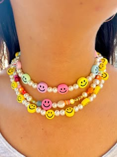 🌈 Cutest pearly rainbow smiley face necklace! 🌈  Getting into summer trends hasn't been more easy. With pastel colors this necklace is the perfect companion to any outfit. The "Smile" collection is meant to be for anyone who likes to have fun and be spontaneous! Materials: Beaded pearls and Smiley faces Electroplated Plastic Mix 14K gold plated lock and extensor Size: 14 inches or 35.6 cm + 2 inch/ 5cm extensor Jewelry Care: *Allow perfumes and lotion to dry before wearing. *Remove before show Smiley Face Bracelets, Trendy Smiley Face Adjustable Necklace, Trendy Smiley Face Jewelry For Summer, Trendy Yellow Beaded Necklaces, Fun Smiley Face Jewelry For Summer, Trendy Rainbow Necklaces For Summer, Fun Summer Jewelry With Smiley Face, Fun Smiley Face Summer Jewelry, Playful Smiley Face Jewelry For Beach