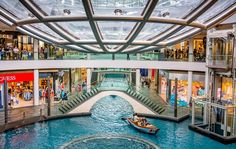 the inside of a shopping mall with a boat in the water