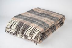 two brown and white plaid blankets folded on top of each other in front of a white background