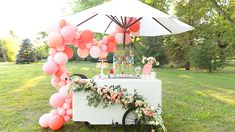 an umbrella and table with balloons on it