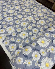 an image of a bed with white and yellow daisies on the sheet coverlet