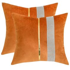 two orange velvet pillows with gold trim