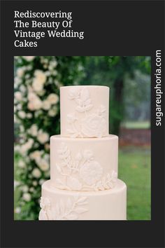 a white wedding cake sitting on top of a lush green field