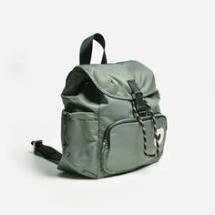 a backpack that is sitting on top of a white surface with a black strap around it