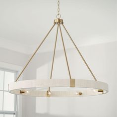 a chandelier hanging from the ceiling in a room with white walls and windows