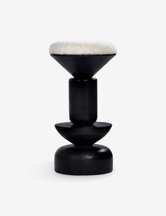 a black stool with a white cushion sitting on top of it