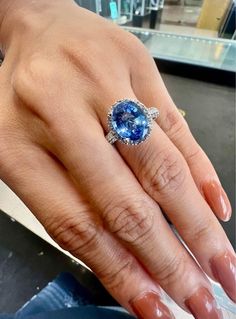 a woman's hand with a ring on it and a blue stone in the middle