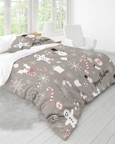 a bed covered in grey and white christmas themed comforter sets with snowmen, ghostes, santa hats and candy canes